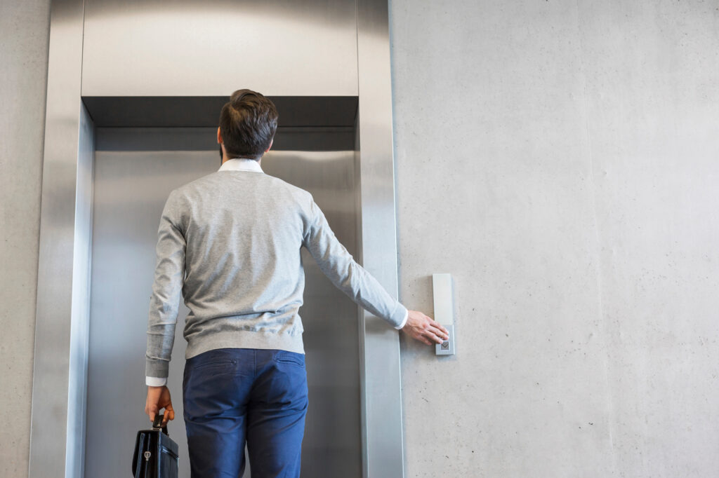 man pressing elevator button