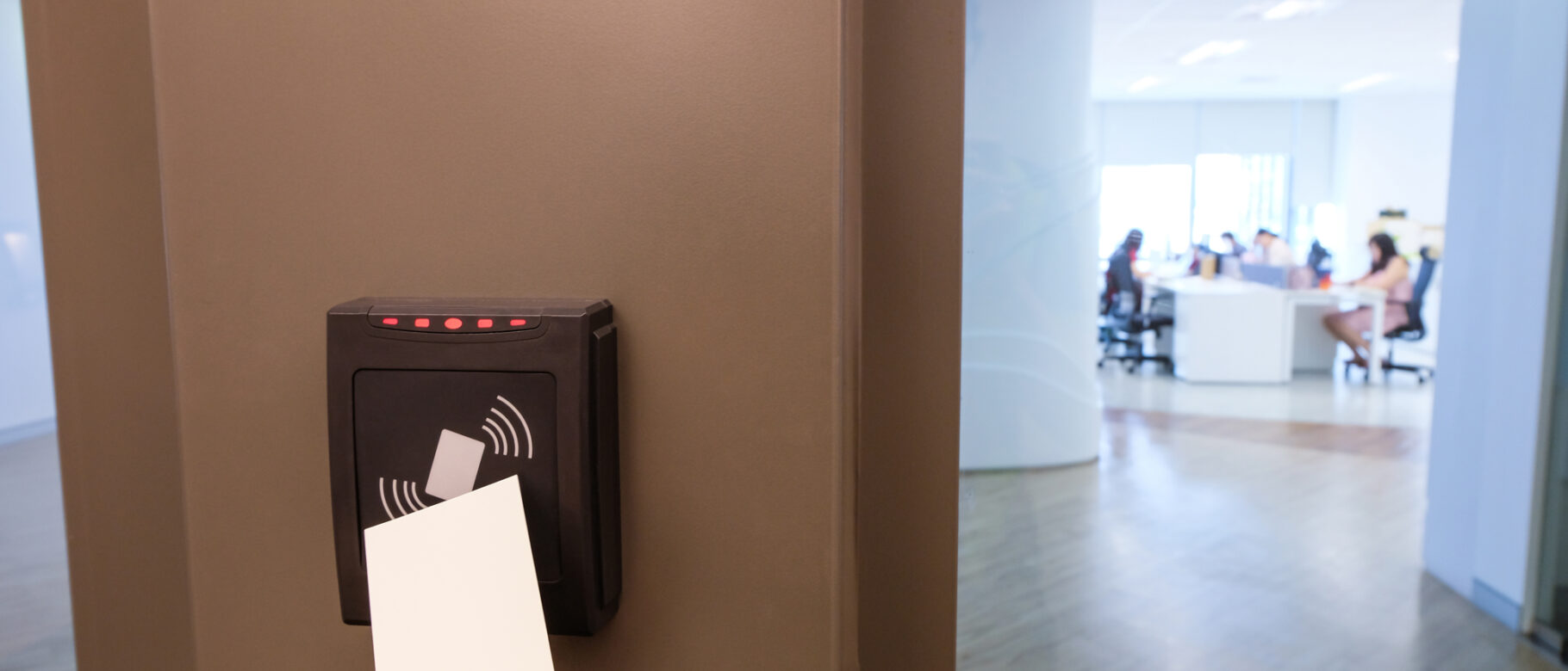 A worker scanning their keycard to enter a building, which uses a card access system.