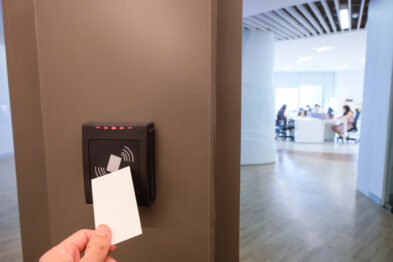 A worker scanning their keycard to enter a building, which uses a card access system.