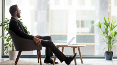 man sitting in chair looking out window