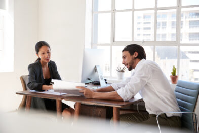 two people working together at desk