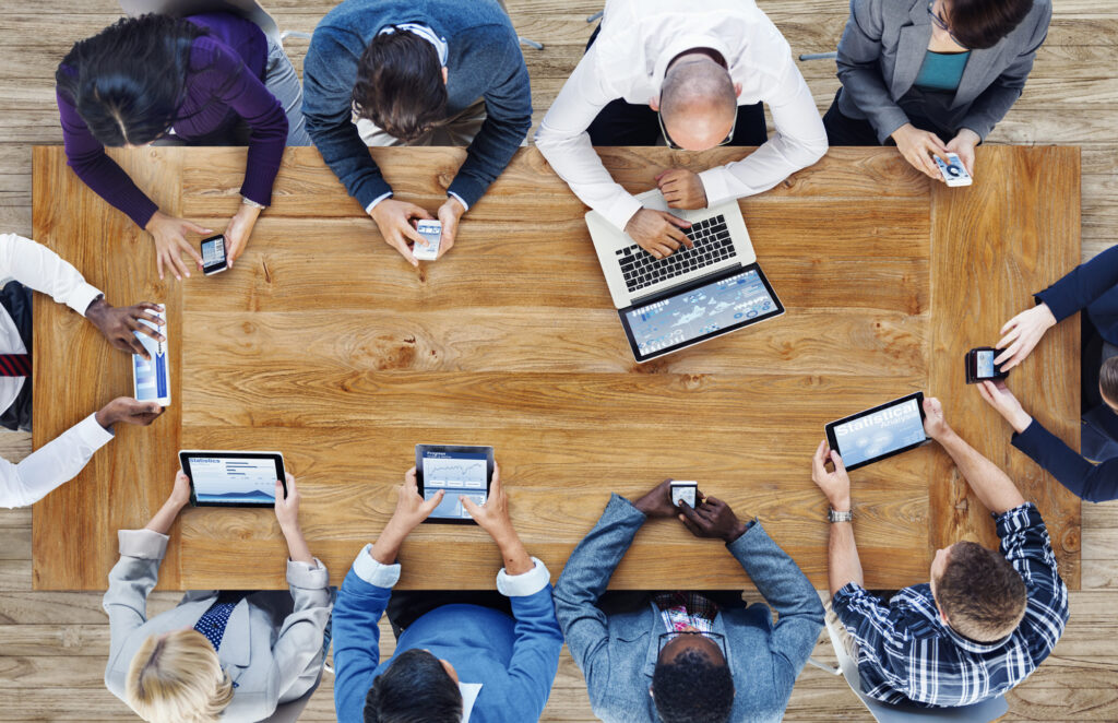 coworkers using different tablets at table