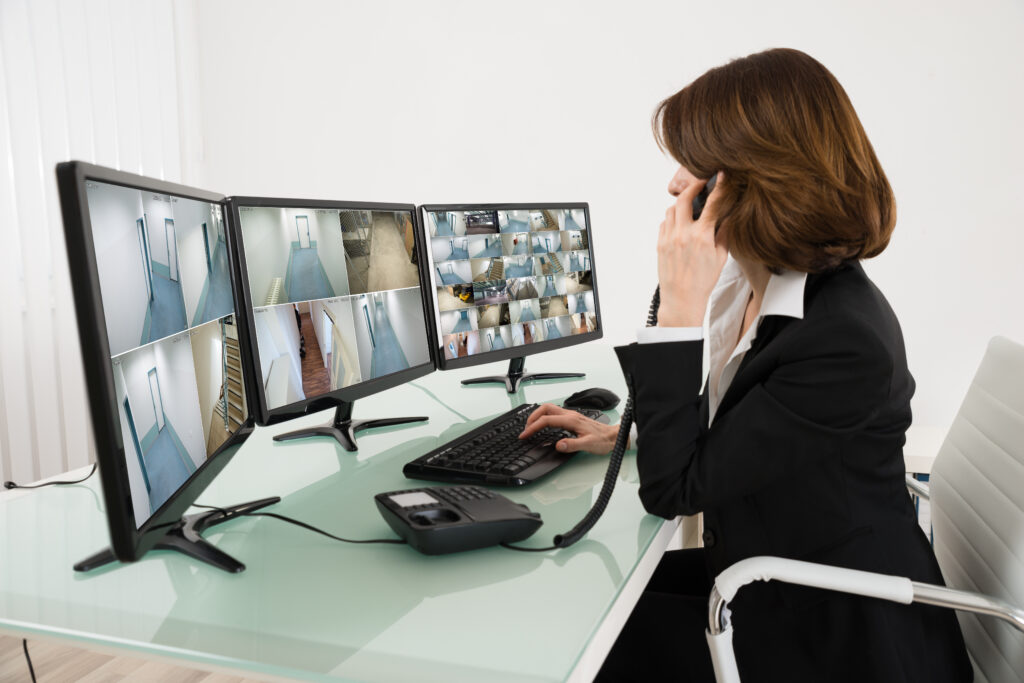 Woman sitting at desk, looking at security cameras