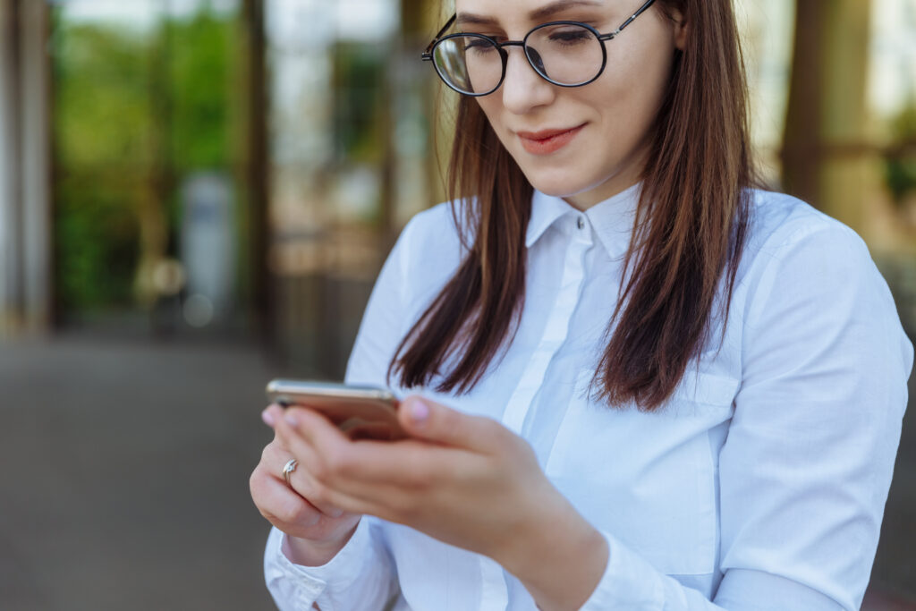 Business woman with glasses looking at smart pone