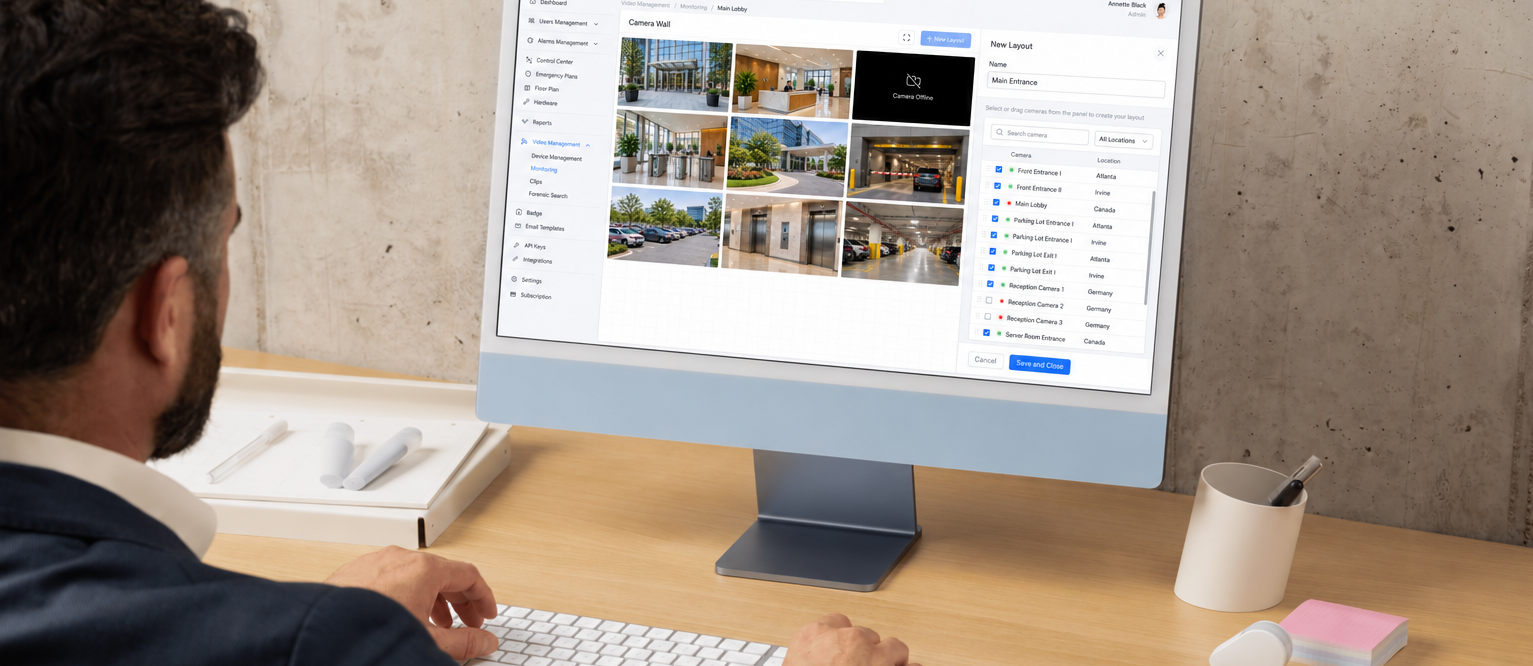 A person in a business suit using a computer to manage a Genea video security camera layout interface.