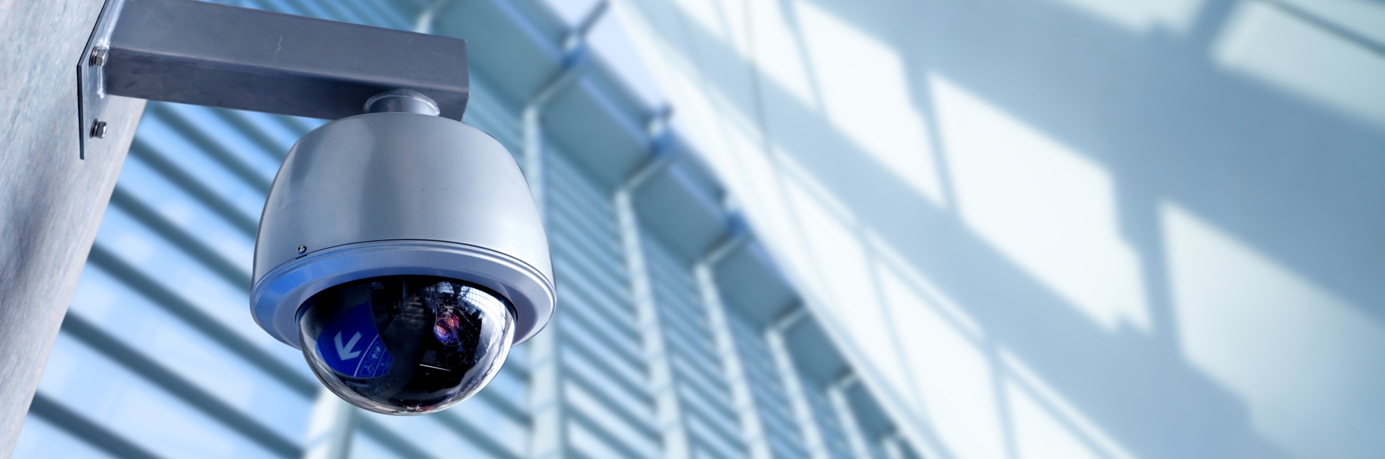 A Genea video dome-style security camera mounted to an exterior wall.